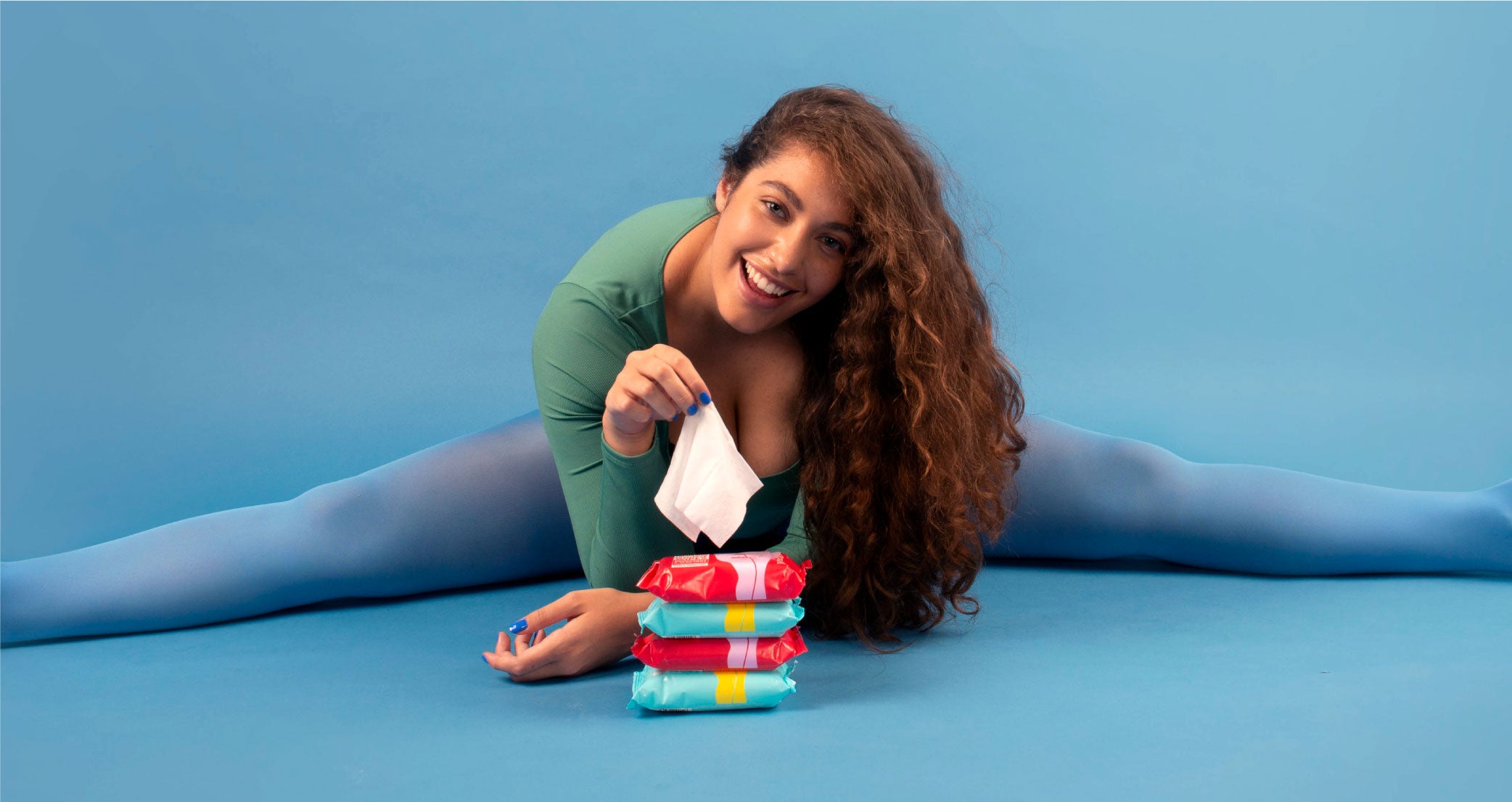 Model doing the splits behind a pile of intimate wipes