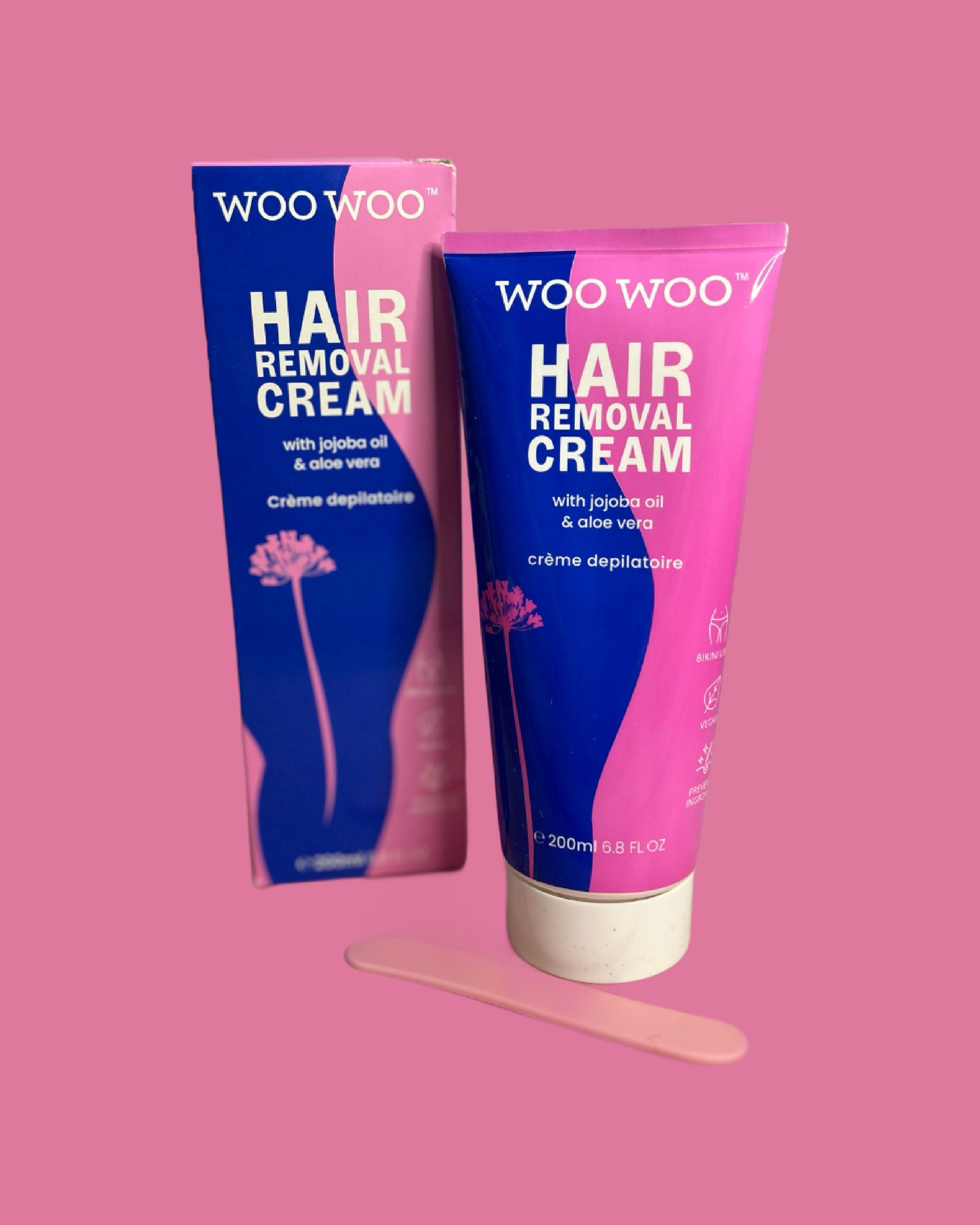 Packaging and tube of WooWoo hair removal cream on pink background