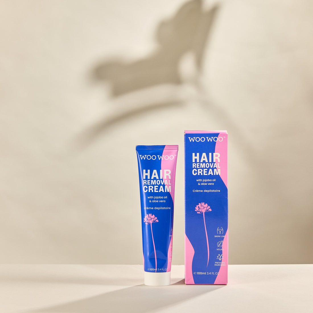 Packaging and tube of Tame It hair removal cream on neutral background